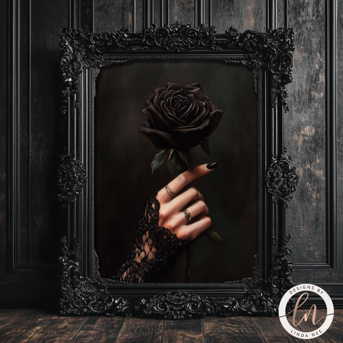 A hand holding a dark rose in an ornate black frame against a dark background.