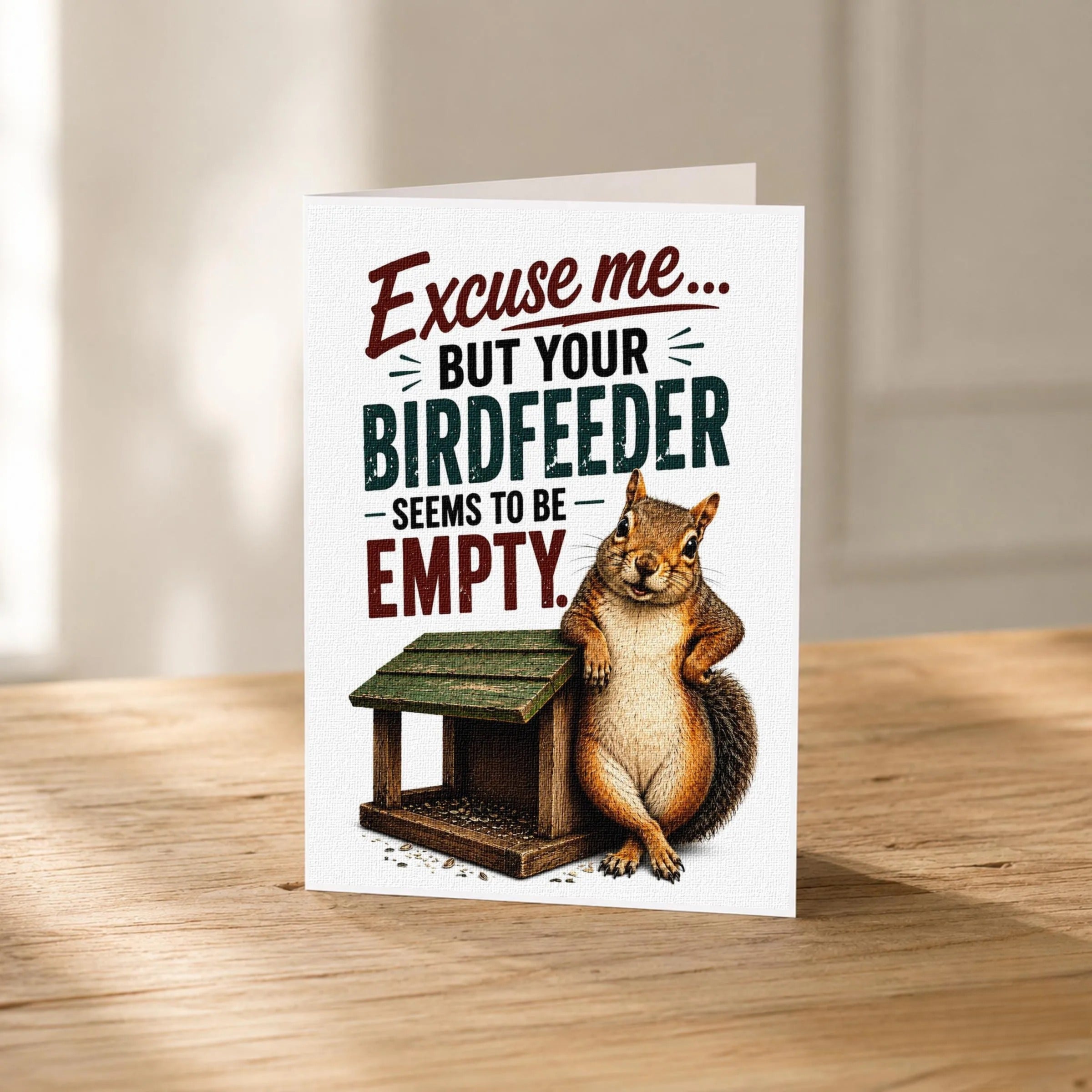 A greeting card with a squirrel sitting on a bird feeder and the text "Excise me... BUT YOUR BIRDFEEDER SEEMS TO BE EMPTY."