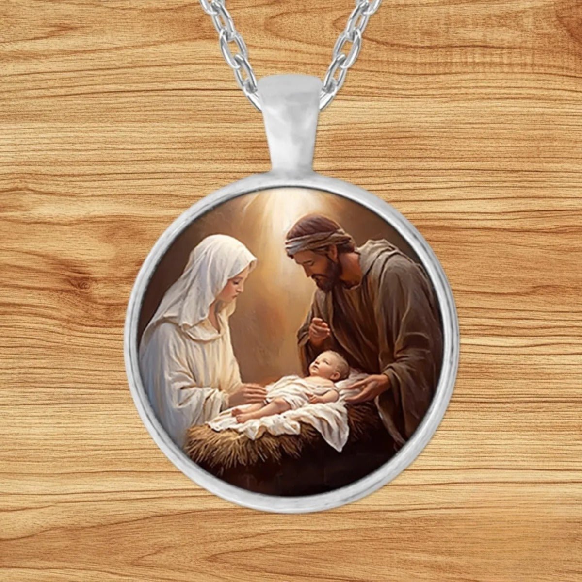 Round silver charm pendant necklace featuring Mary, Joseph, and Baby Jesus rendered in classical religious oil painting style