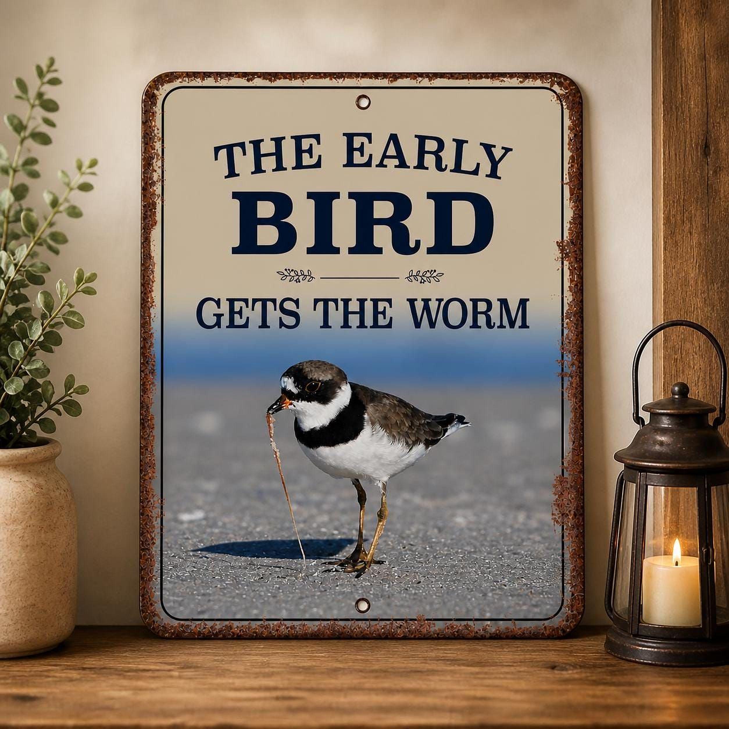 a sign with the text "The early bird gets the worm" and a photograph of a semipalmated plover bird eating a worm.