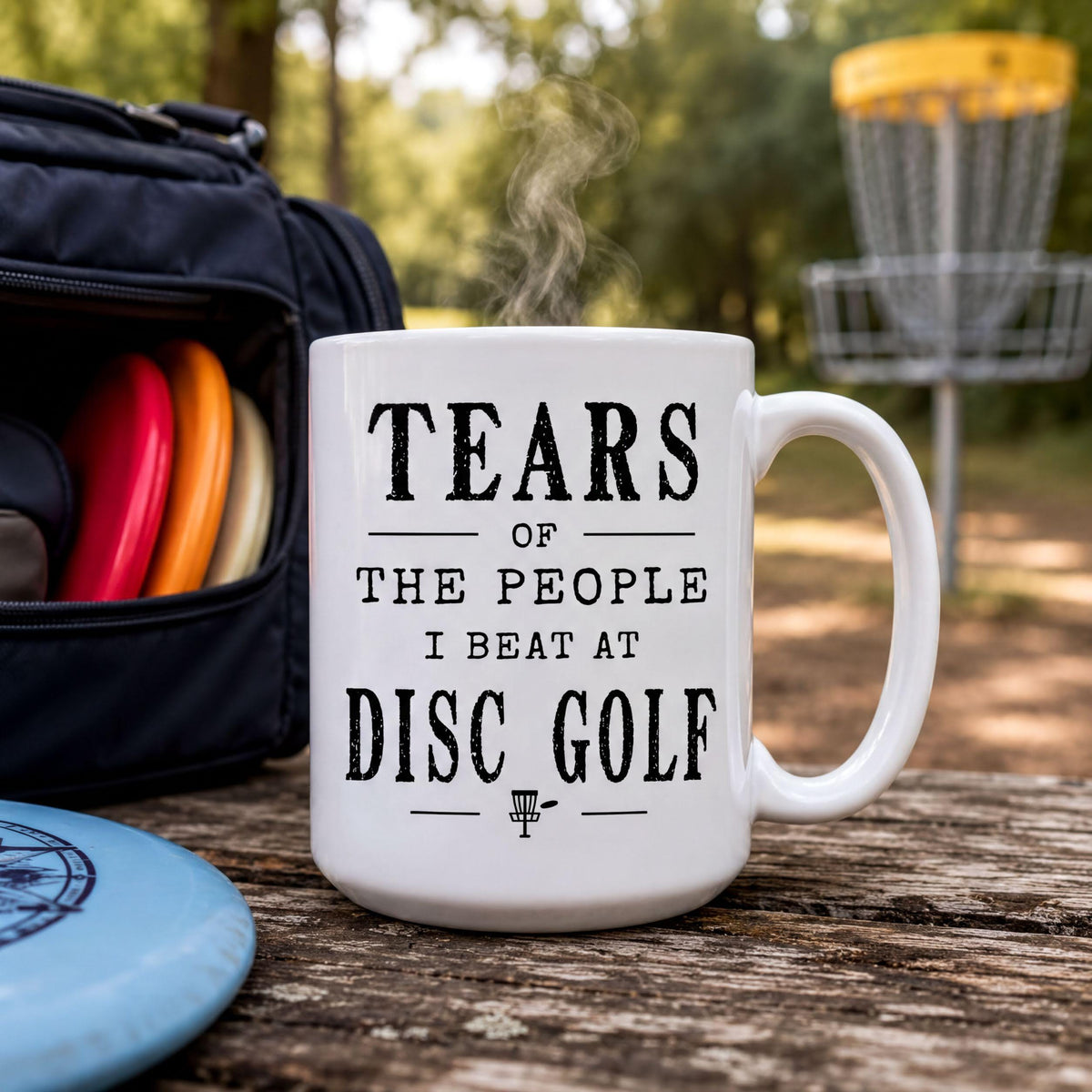 Disc golf mug on a wooden surface with a disc bag and a chain basket in the background