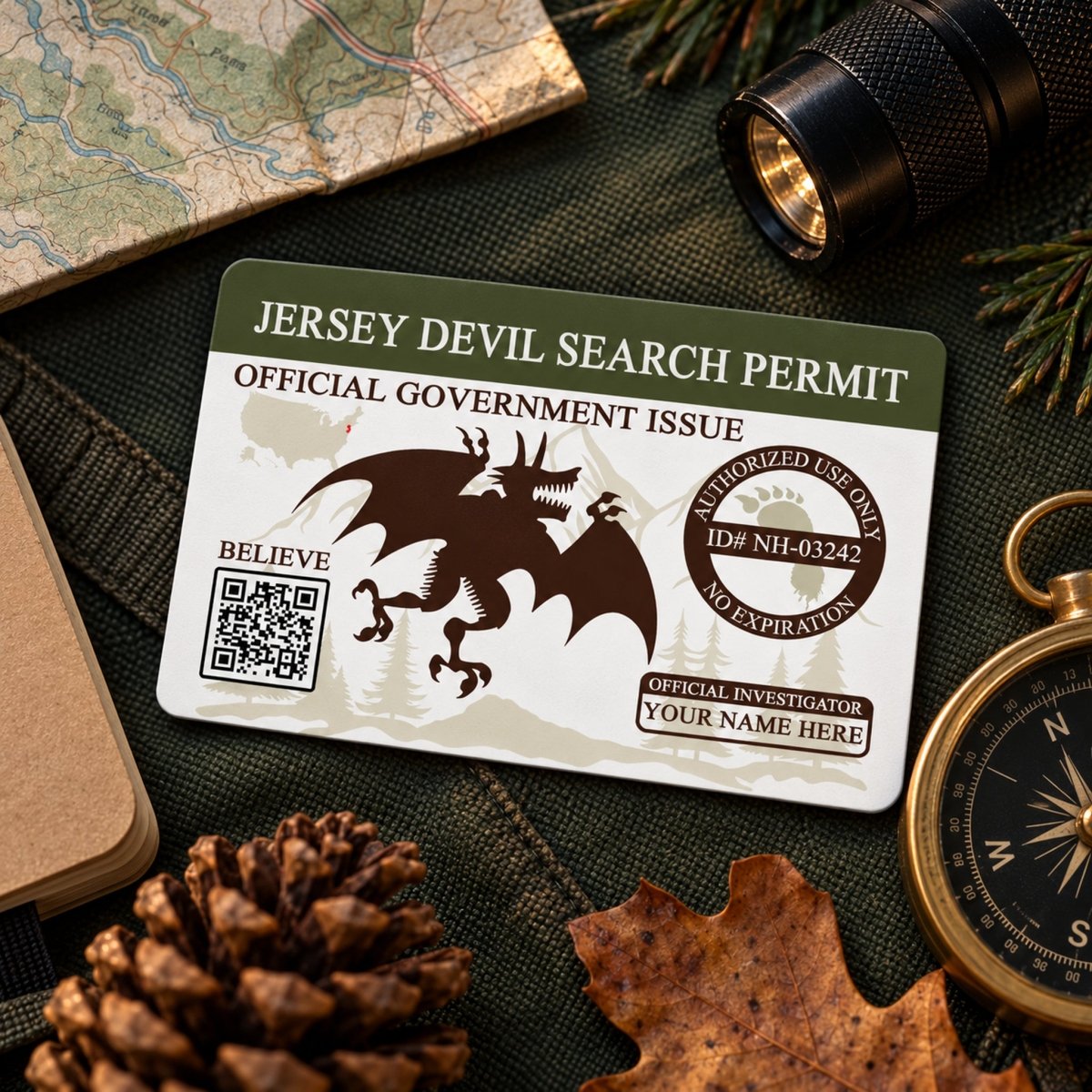 a Jersey Devil search permit, a document that allows the official government to conduct a search, along with a compass, a flashlight, and some pine cones.
