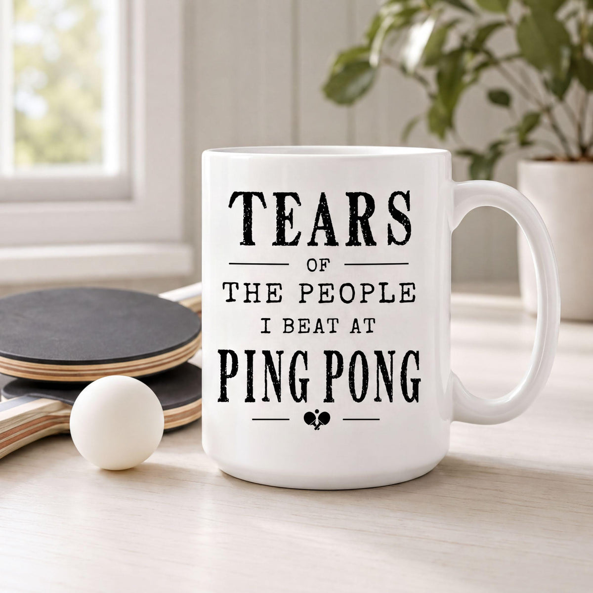 Ping pong mug next to a table tennis paddle and a white ball, quote reading Tears of the people I beat at ping pong