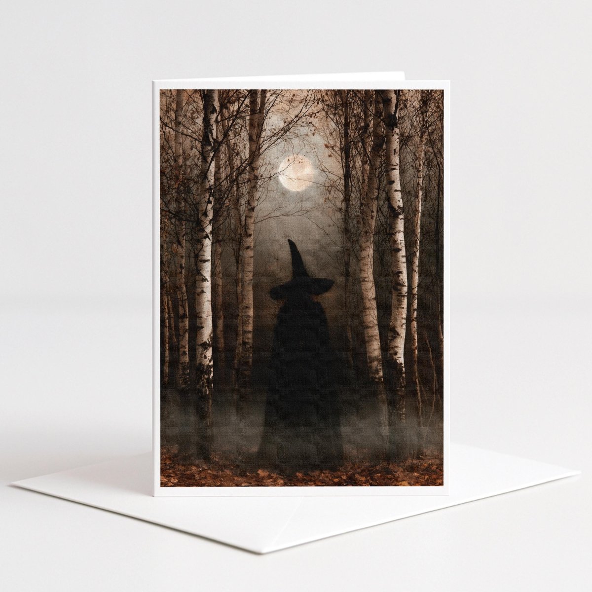 Cloaked witch standing among pale birch trees under a full moon, Halloween note card art