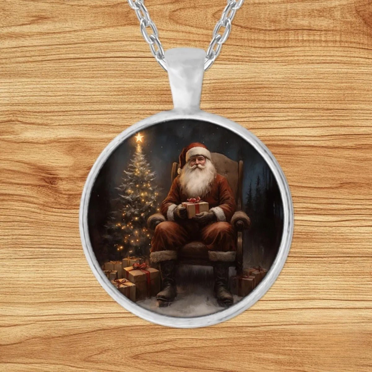 Round silver charm pendant necklace featuring Santa Claus seated in a rocking chair holding a wrapped gift beside a glowing Christmas tree