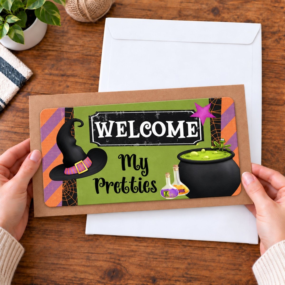 Welcome My Pretties sign held in hand to show size