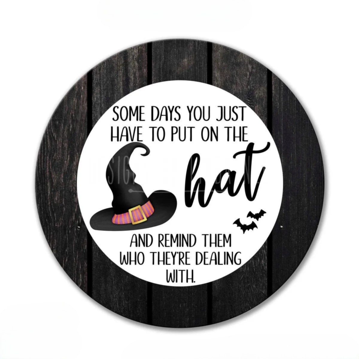 a round sign with a black background and a white border. The sign contains a humorous text that reads "Some days you just have to put on the hat and remind them who they're dealing with."
