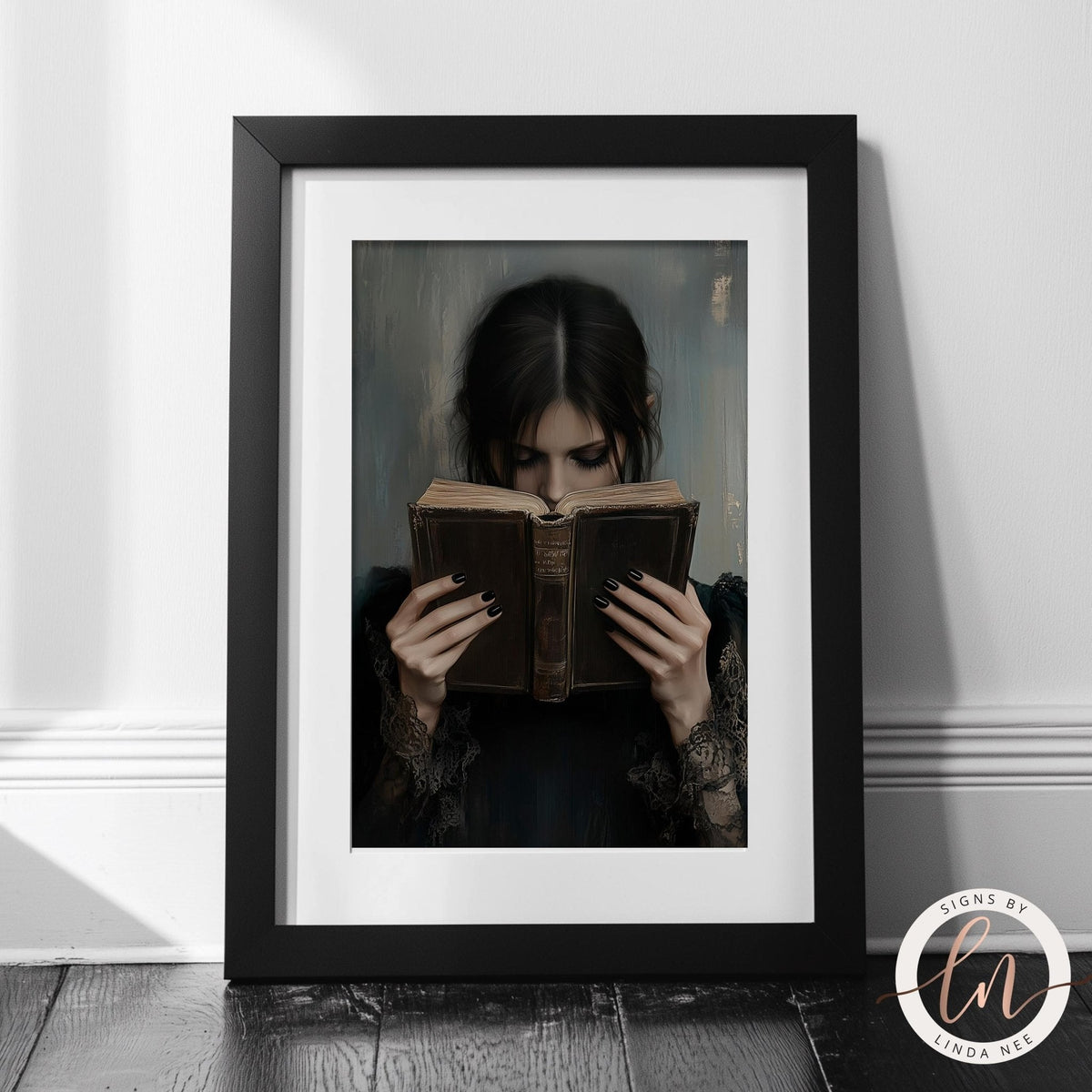 A woman is reading a book in an ornate gold frame, which is displayed on a dark background.