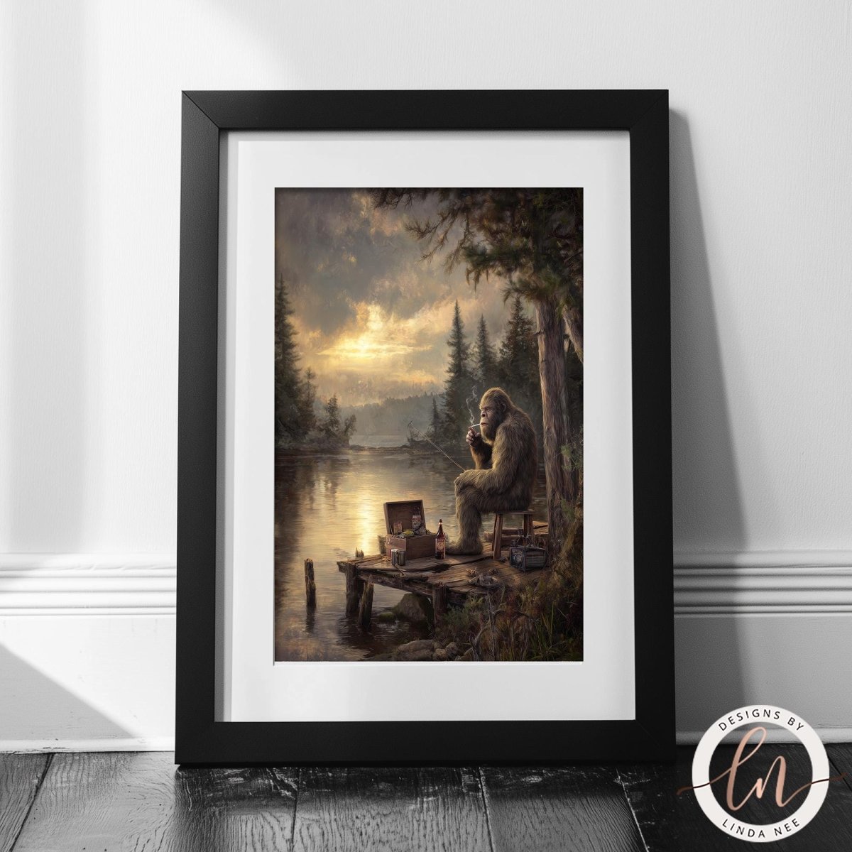 A framed painting depicting a person sitting on a dock, overlooking a body of water with trees and a cloudy sky in the background.