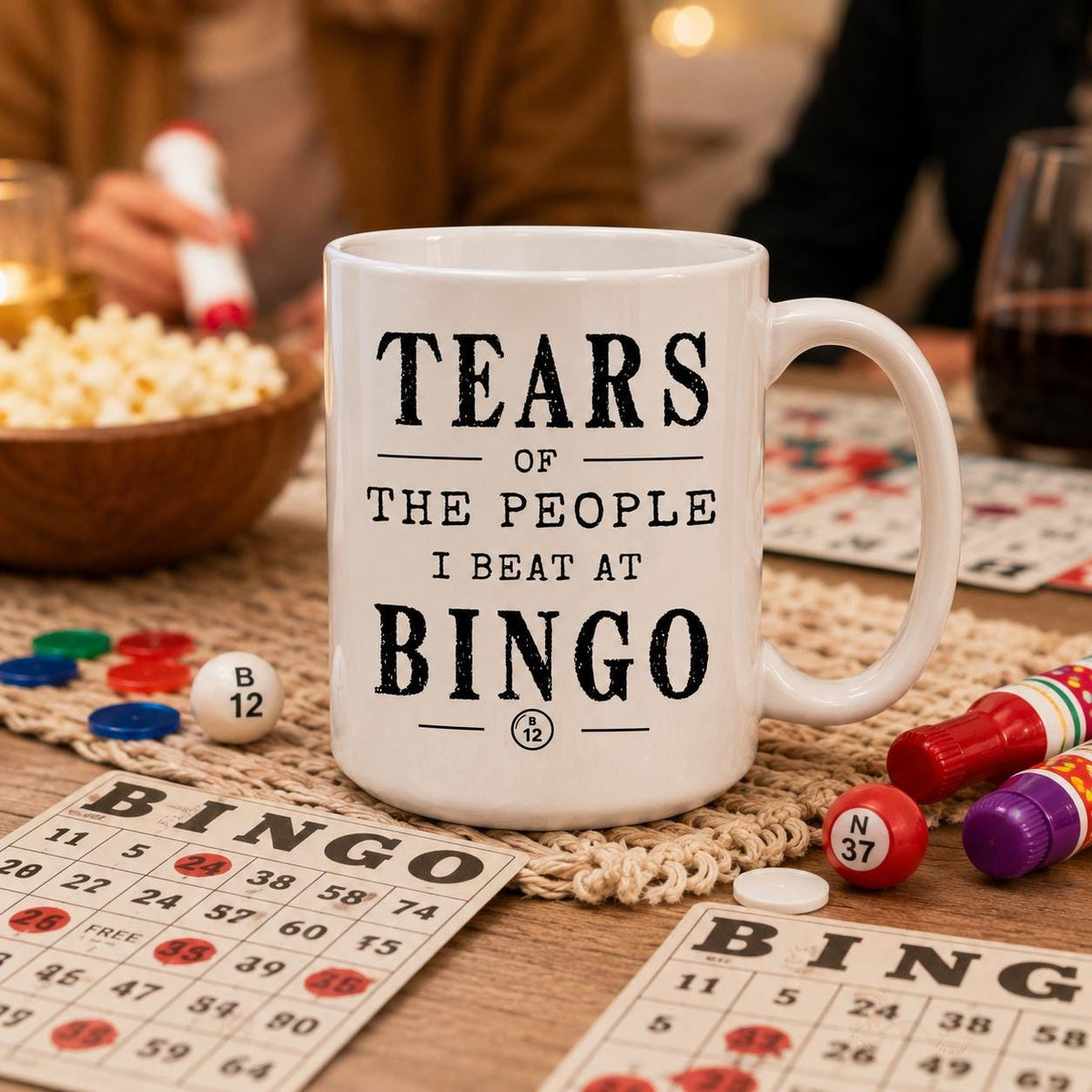 Bingo mug on a table surrounded by bingo cards and game pieces, quote reading Tears of the people I beat at bingo