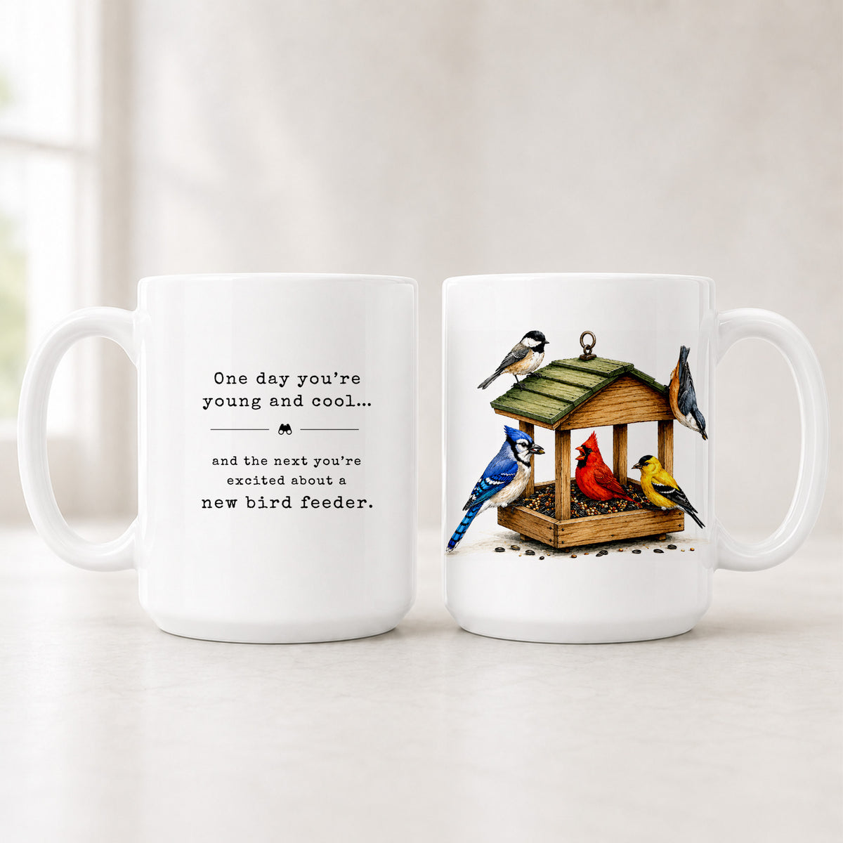 Front and back of the 15 oz bird feeder mug, the young and cool quote on one side and five birds at a feeder on the other