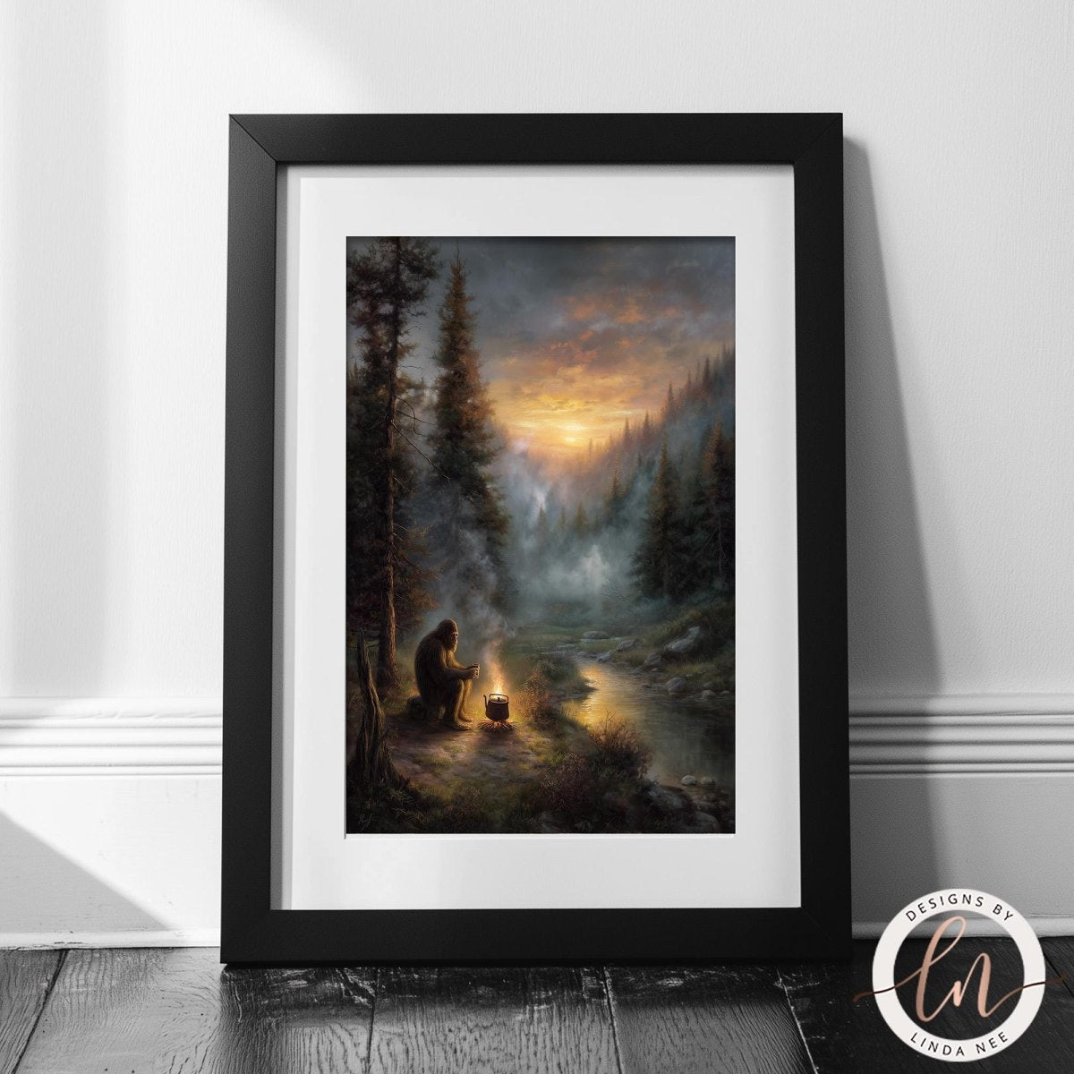 Fine art by Linda Nee featuring Bigfoot seated beside a glowing campfire in a misty evergreen forest at sunset, drinking coffee near a quiet river with moody woodland atmosphere.