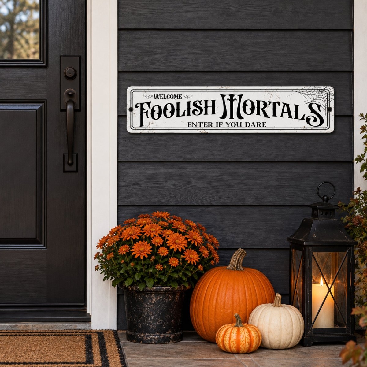Enter If You Dare Halloween sign on a black front door with a lantern and pumpkins