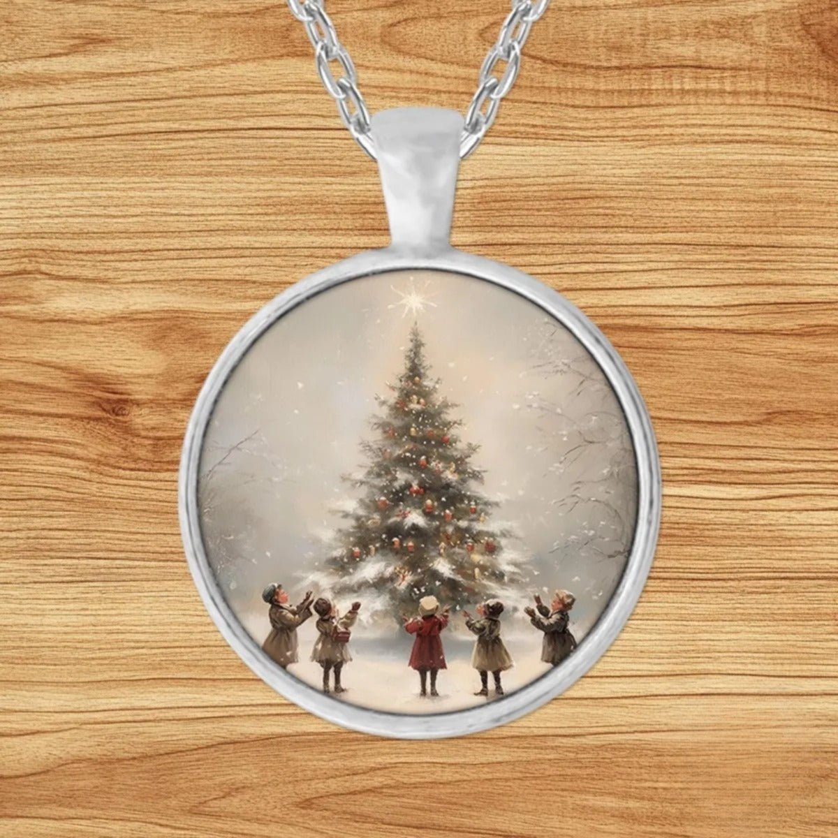 Round silver charm pendant necklace featuring children in vintage coats and bonnets gathered around a decorated Christmas tree