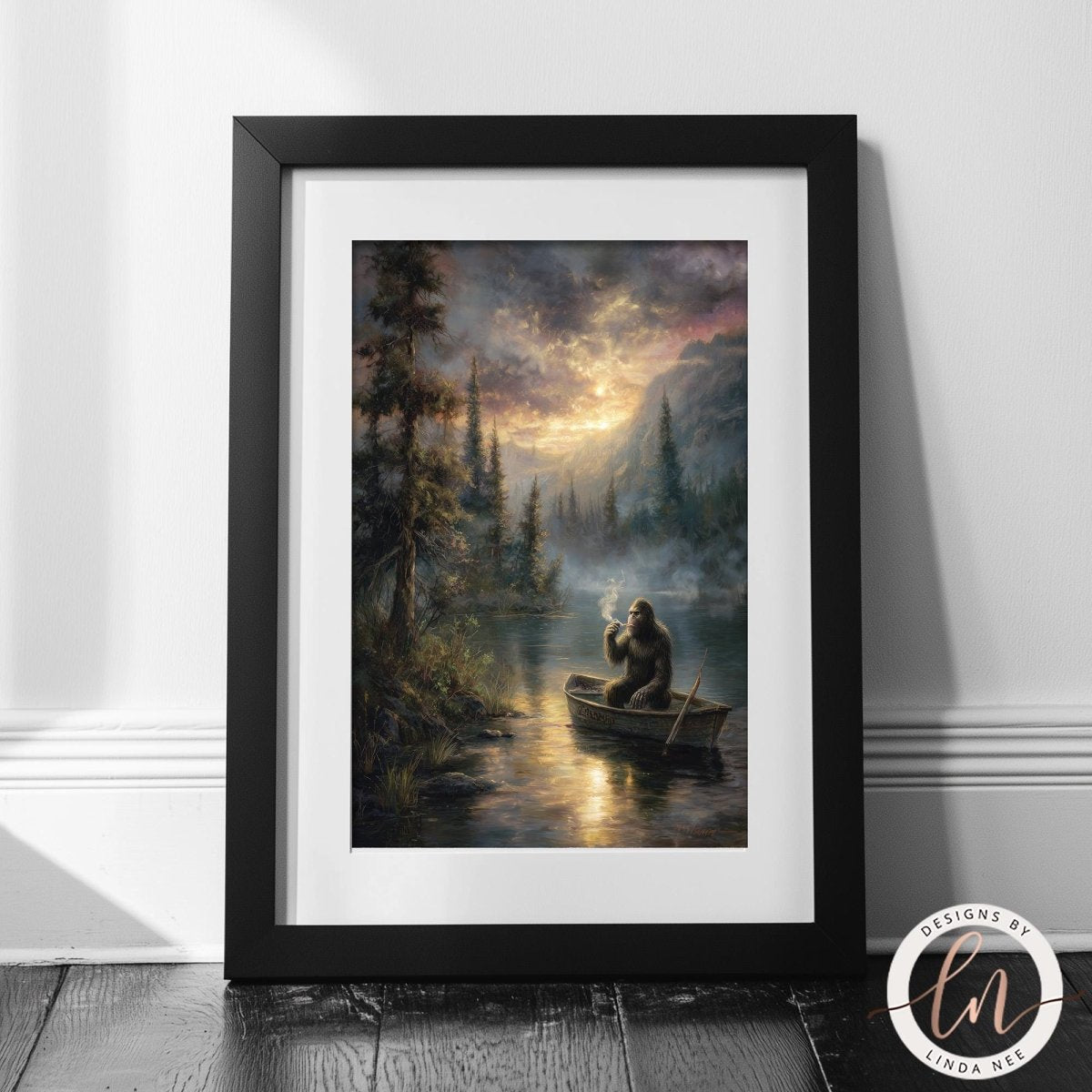 The image is a framed painting depicting Bigfoot sitting in a boat on a lake, surrounded by a forest and a dramatic sky with clouds and sun.