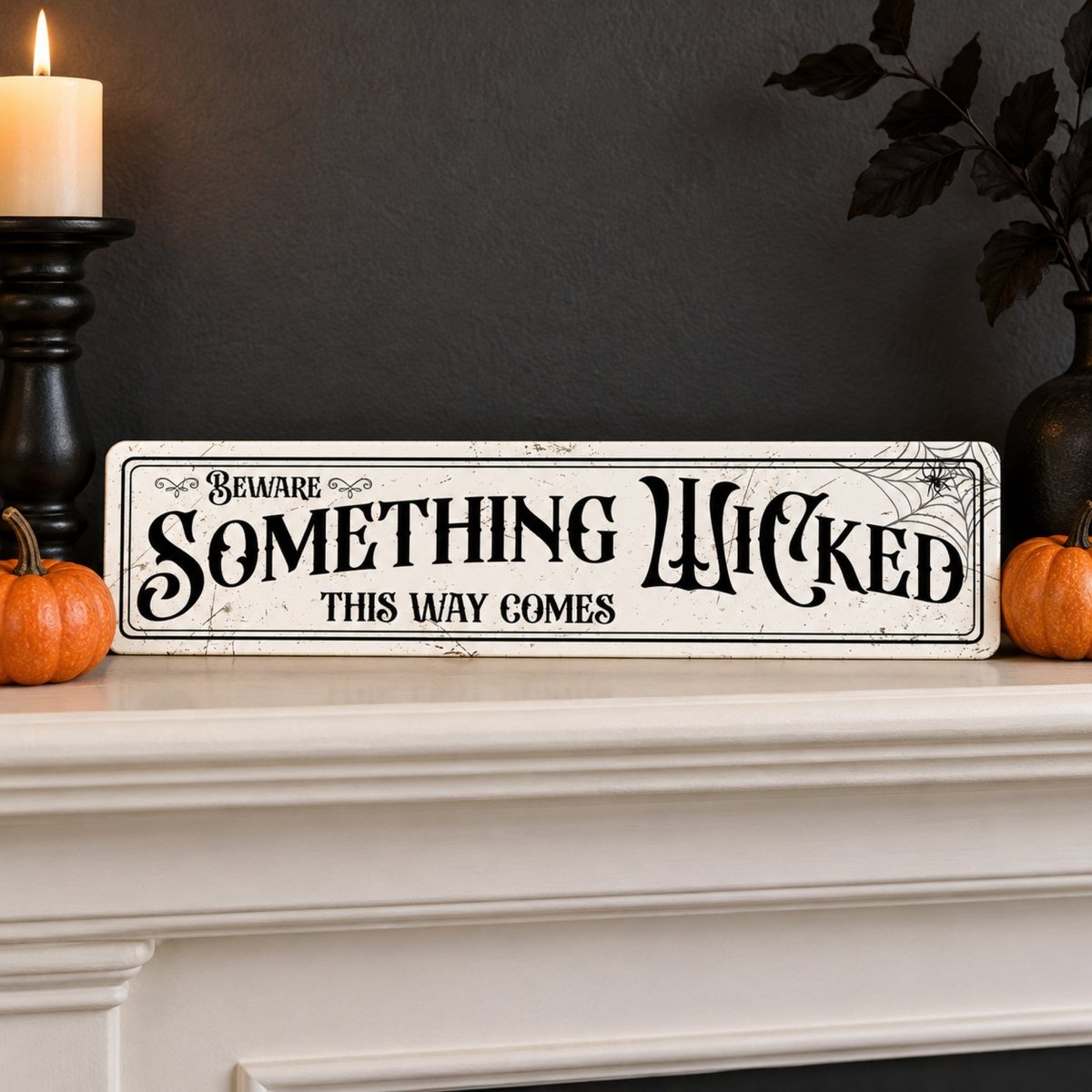 Beware Something Wicked street sign on a white mantel with pumpkins and a candle