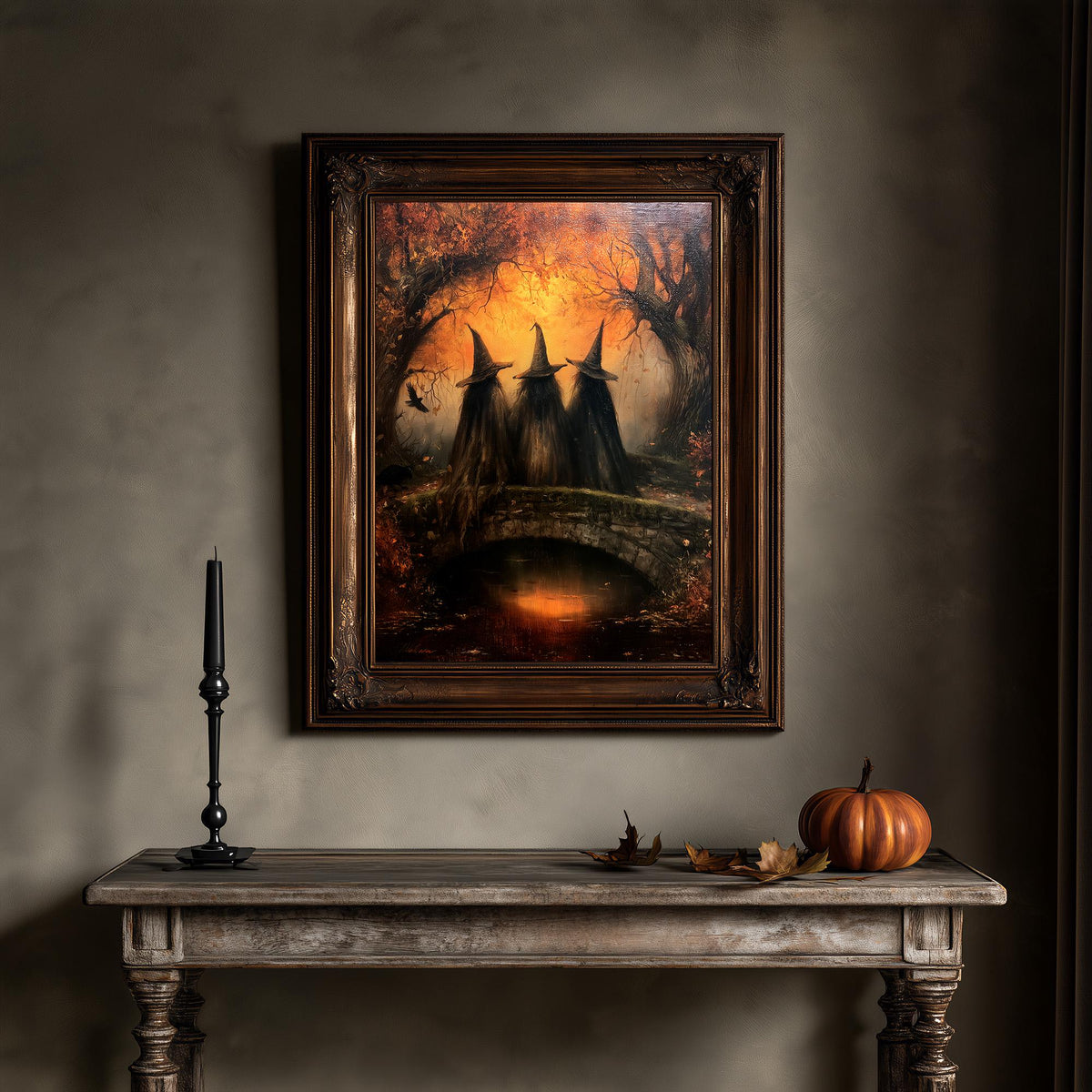 Witchcore wall art above a table holding a pumpkin and a single candle