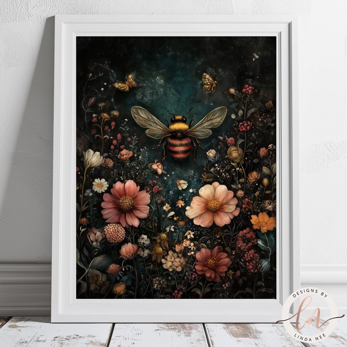 A framed art print featuring a detailed, vintage-style illustration of a large bumblebee surrounded by a dense field of colorful flowers on a dark, textured background. The print is housed in a clean white frame and is displayed leaning against a white wall on a rustic white wooden floor.