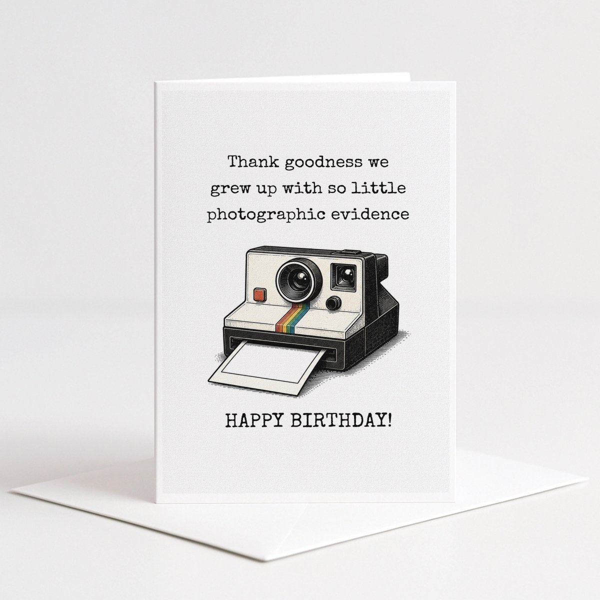 A greeting card with a Polaroid camera and the text "Thank goodness we grew up with so little photographic evidence" and "Happy birthday!"