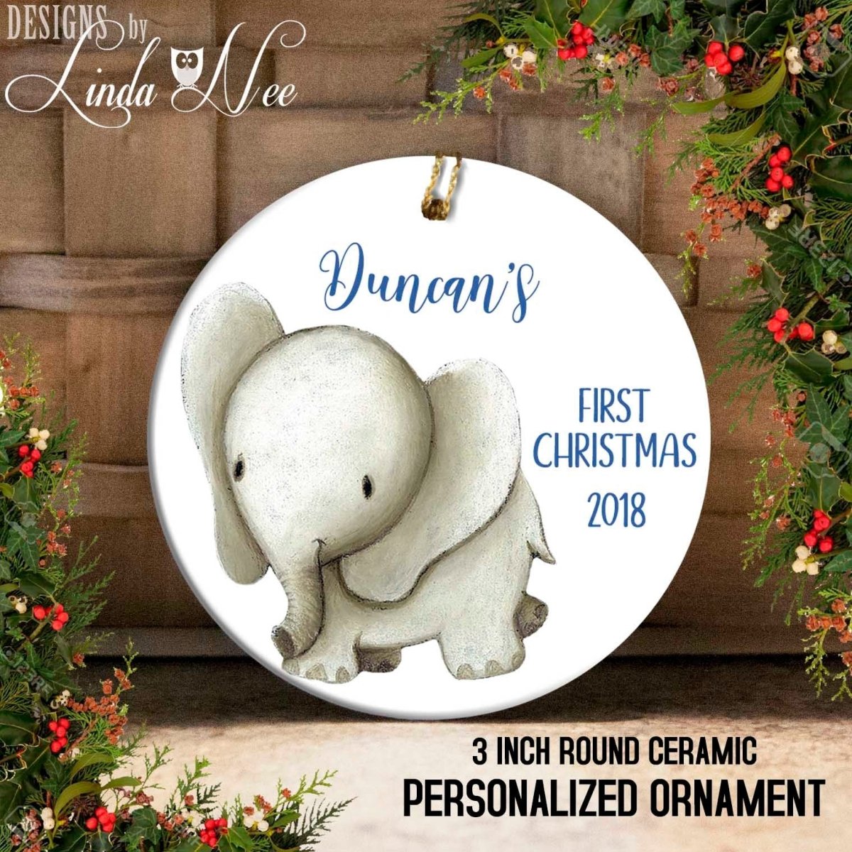Round ceramic personalized ornament with an elephant design and text 'Duncan's First Christmas 2018' on a decorative background.