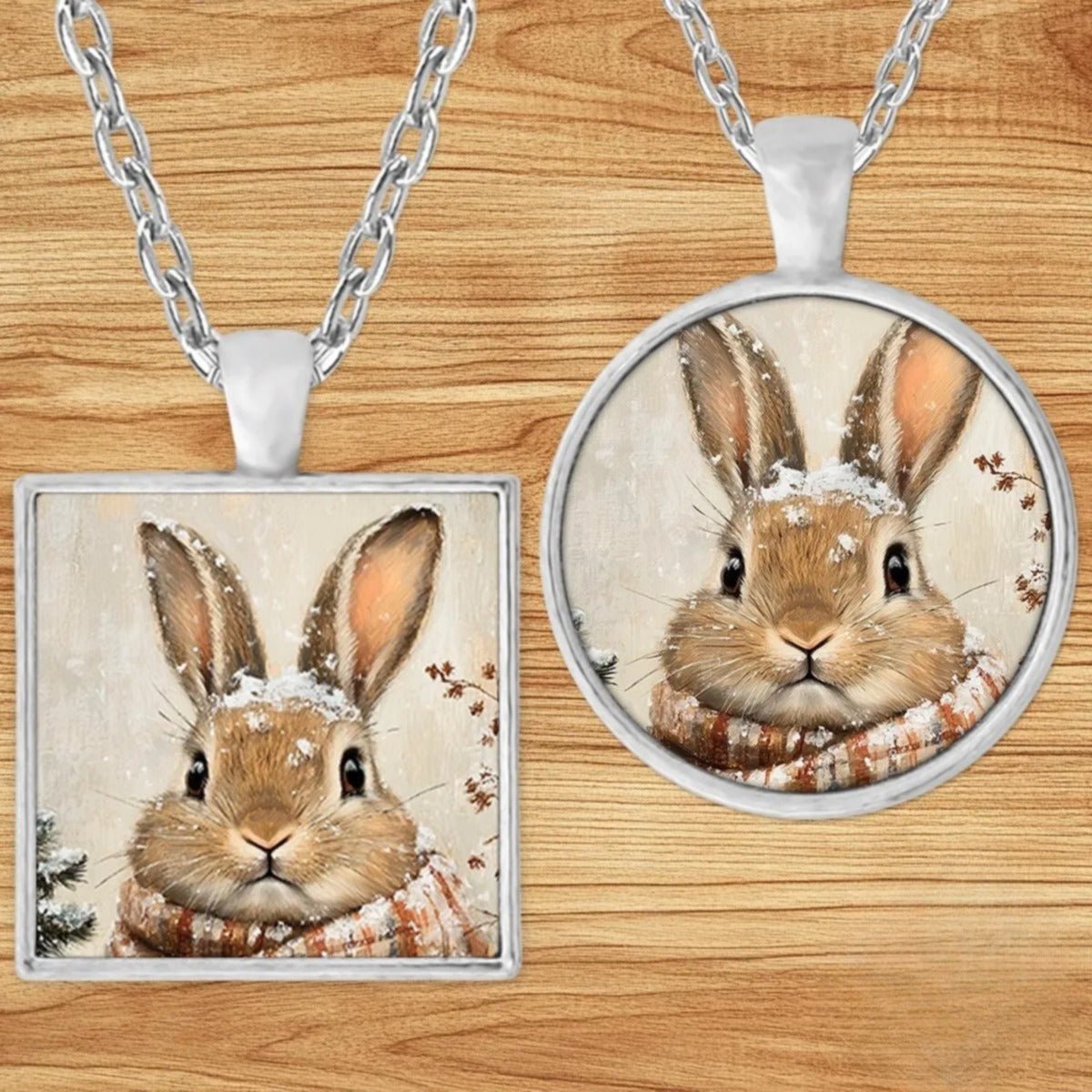 Bunny in a Plaid Scarf pendant necklace shown in round and square silver charm styles on a wood background