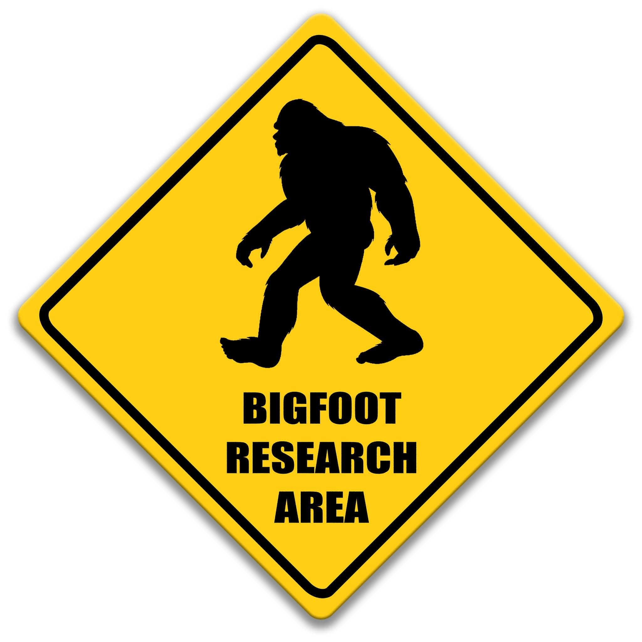 Yellow metal sign with Bigfoot silhouette and text reading “Bigfoot Research Area,” humorous cryptid warning wall decor.