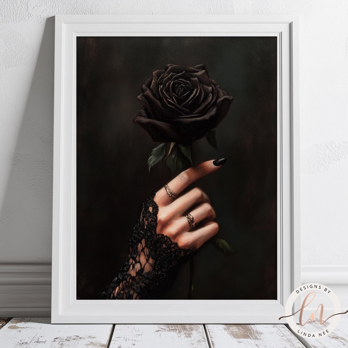 Framed artwork of a hand holding a black rose against a dark background.