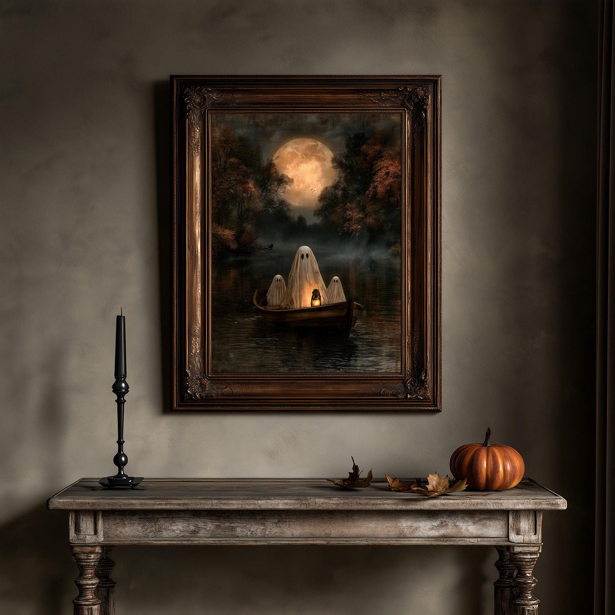 Moonlit lake wall art above a wooden table holding a candle and a pumpkin