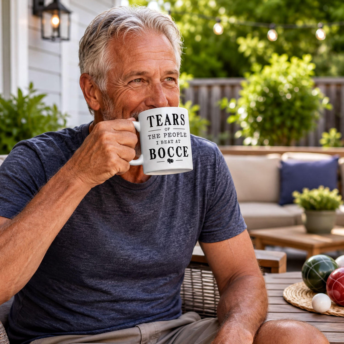 Man relaxing on a patio holding the funny bocce mug with its black distressed quote