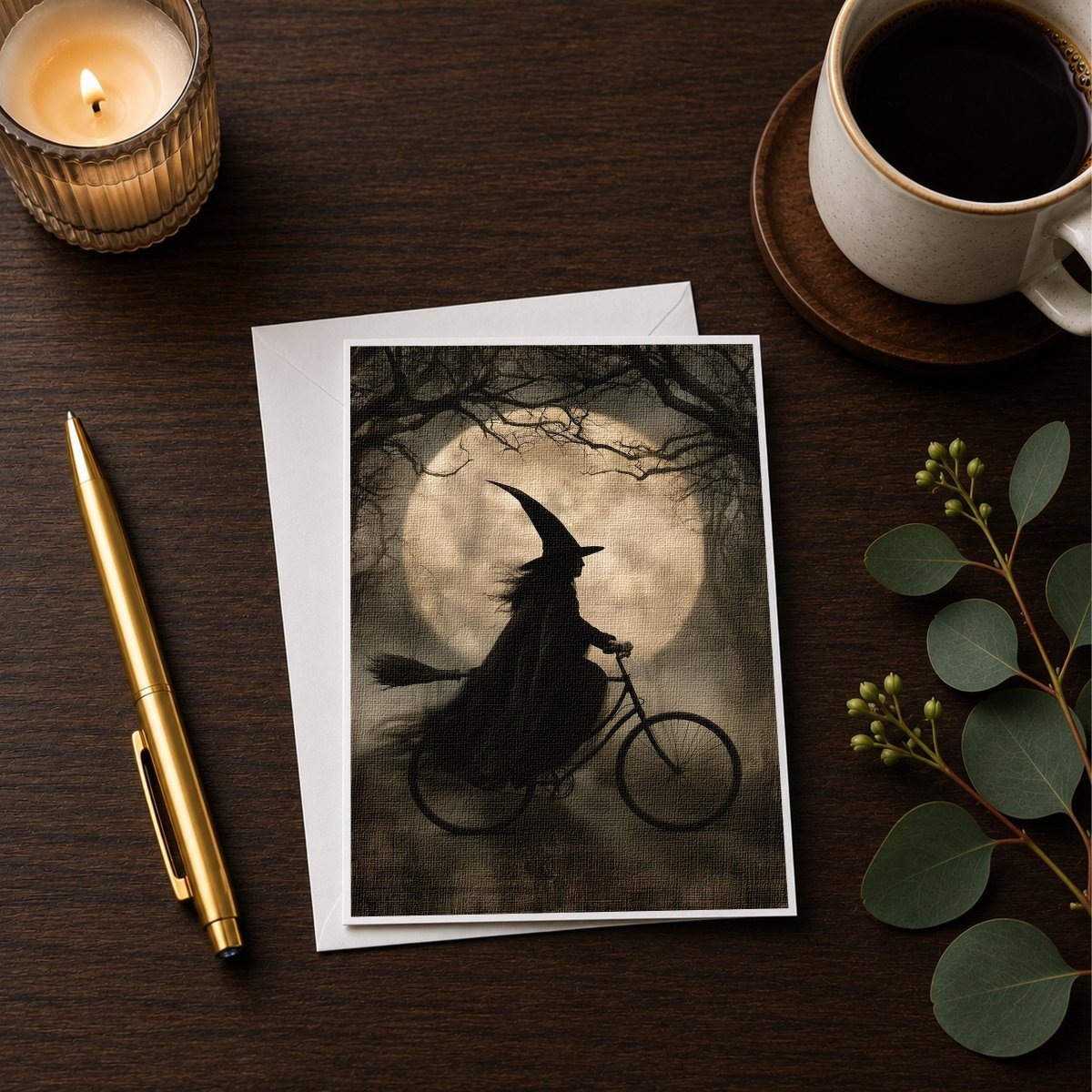 Vintage witch on a bicycle note card styled with a candle, pen, and coffee