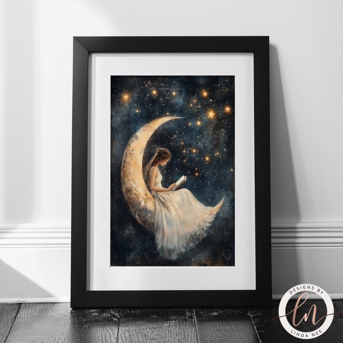 A framed painting depicting a woman sitting on a crescent moon, reading a book, with a starry night sky in the background.
