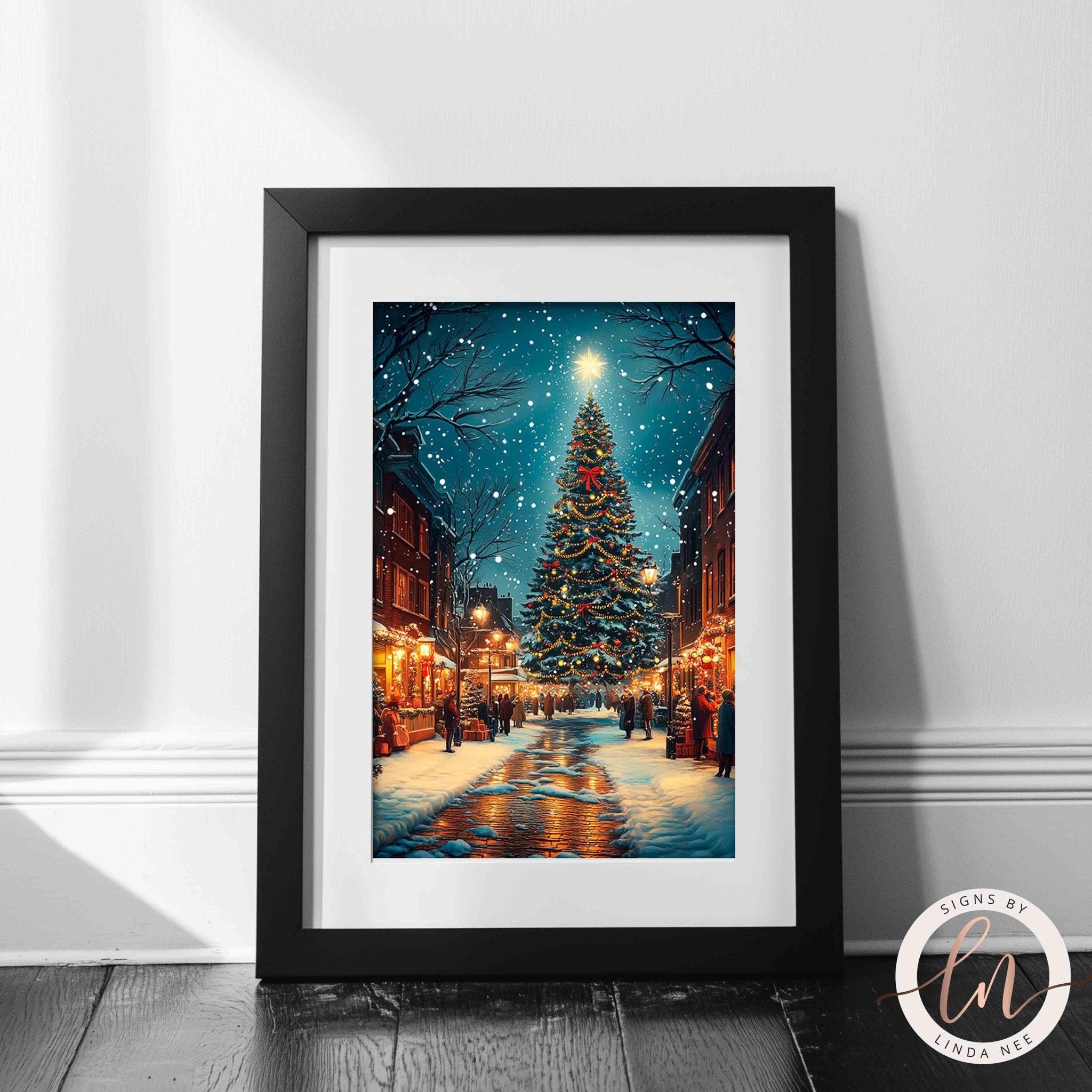 A framed photograph depicting a snowy street scene with a large Christmas tree in the center, surrounded by buildings and people walking along the snow-covered sidewalk.