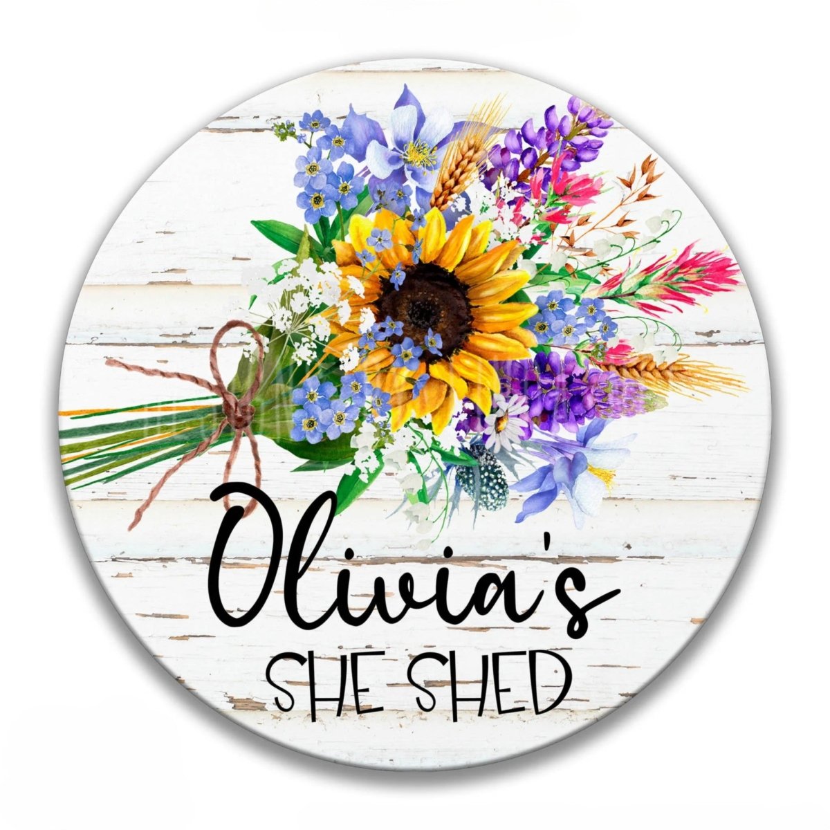 The image is a round sign with a floral design featuring a sunflower and various other flowers. The sign has a protective coating and is made of American-made materials. The text on the sign reads "Olivia's shed".