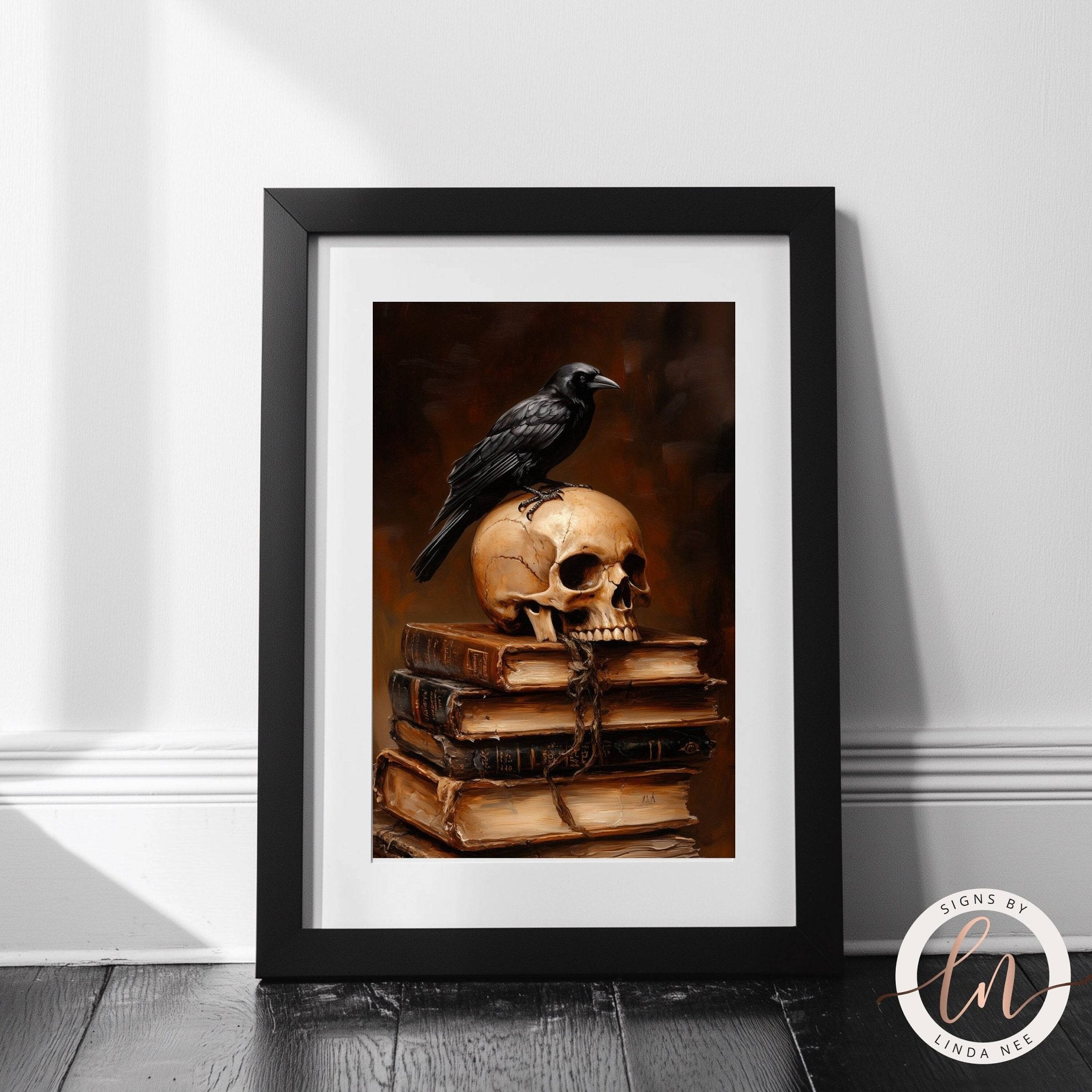 A framed image depicting a black crow perched on a skull, which is placed on top of a stack of books.