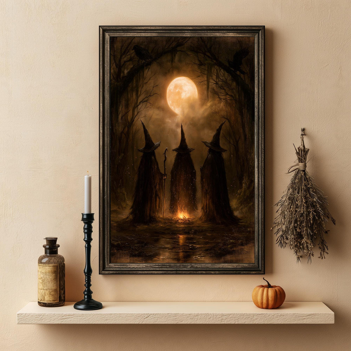 Three witches art print above a shelf with a lit candle and a small pumpkin