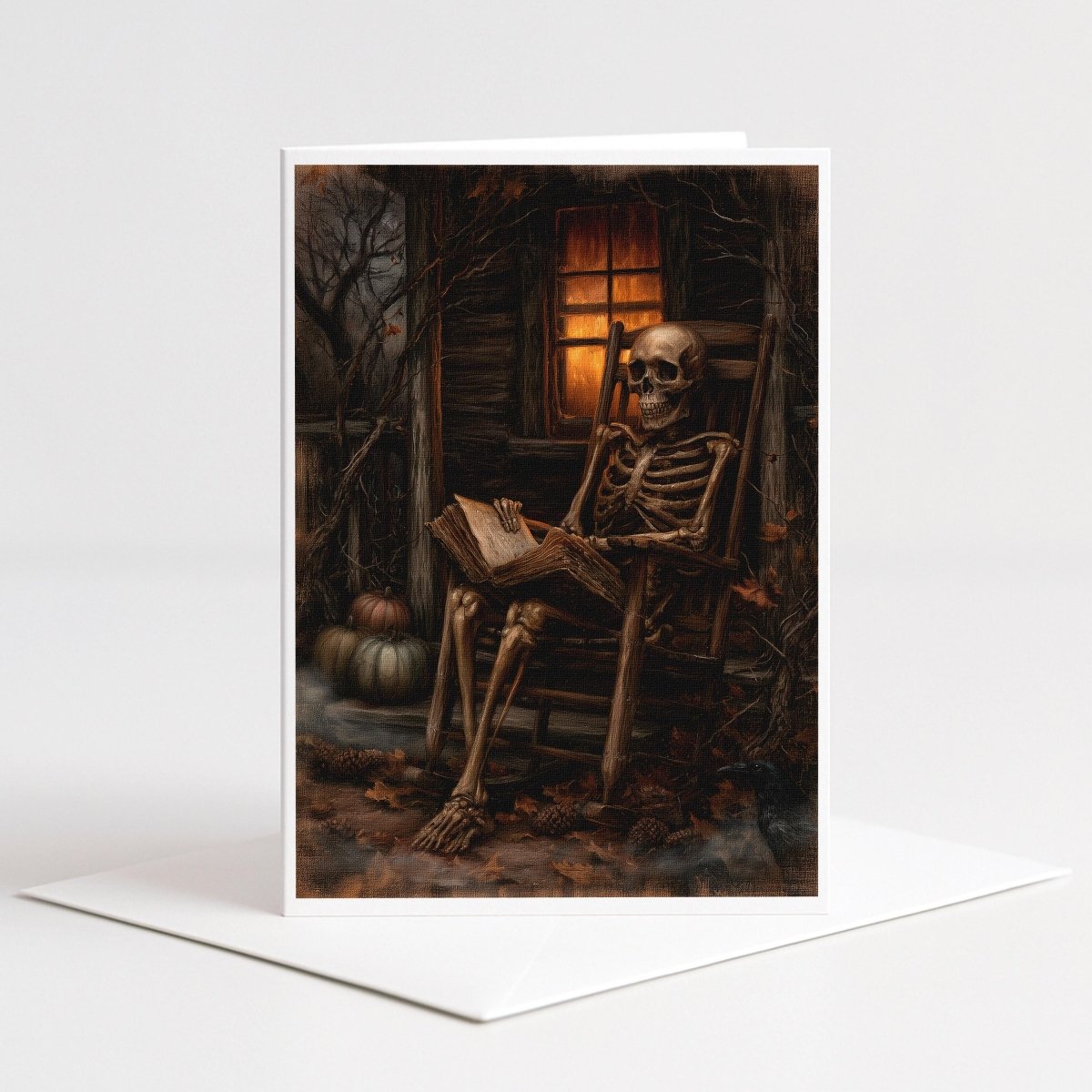 Skeleton reading Halloween note card art of a skeleton in a rocking chair with a book and pumpkins