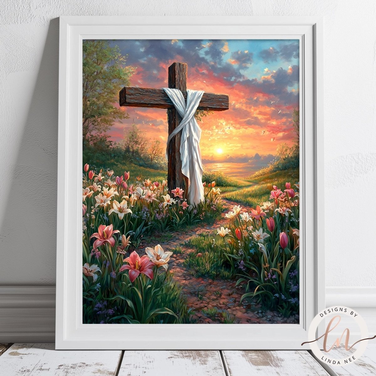 A framed painting depicting a cross surrounded by a vibrant garden filled with colorful flowers, set against a backdrop of a colorful sunset sky.