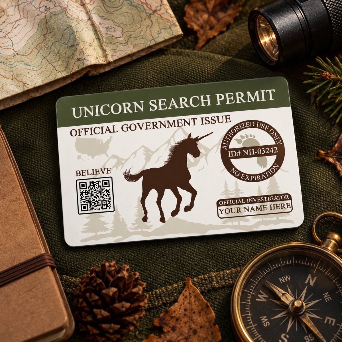 a unicorn-themed official government permit, a compass, a magnifying glass, pine cones, and a map, all arranged on a surface.