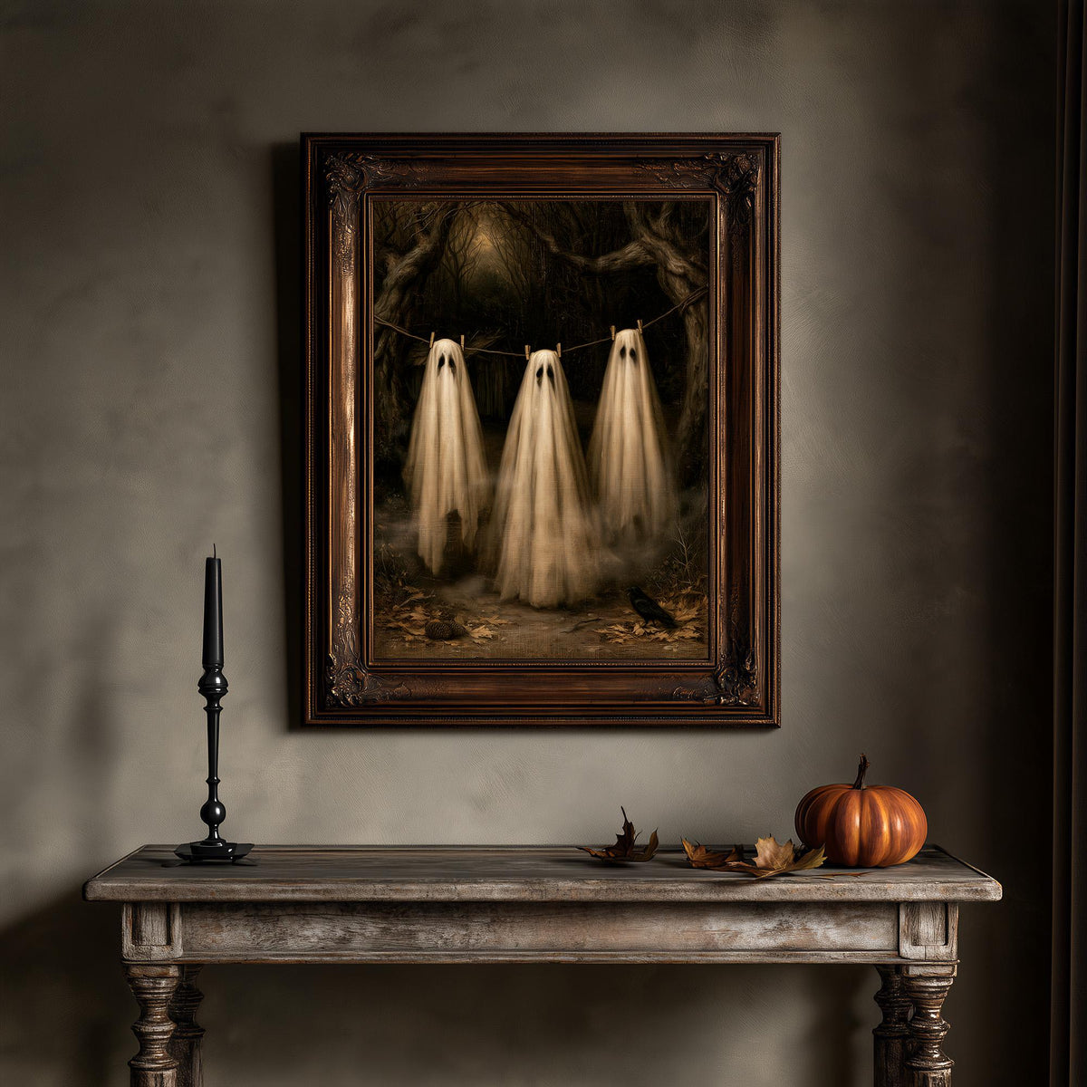 Ghost art print on a wall above a wooden table with a candle and a small pumpkin