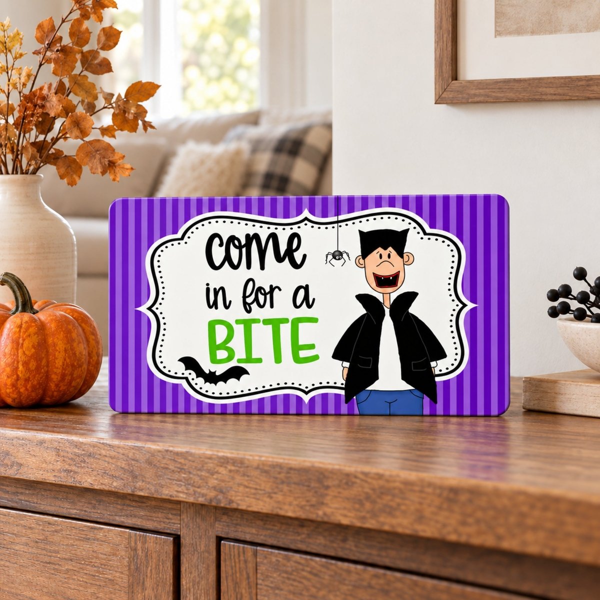 Come In for a Bite sign on a shelf with fall decor