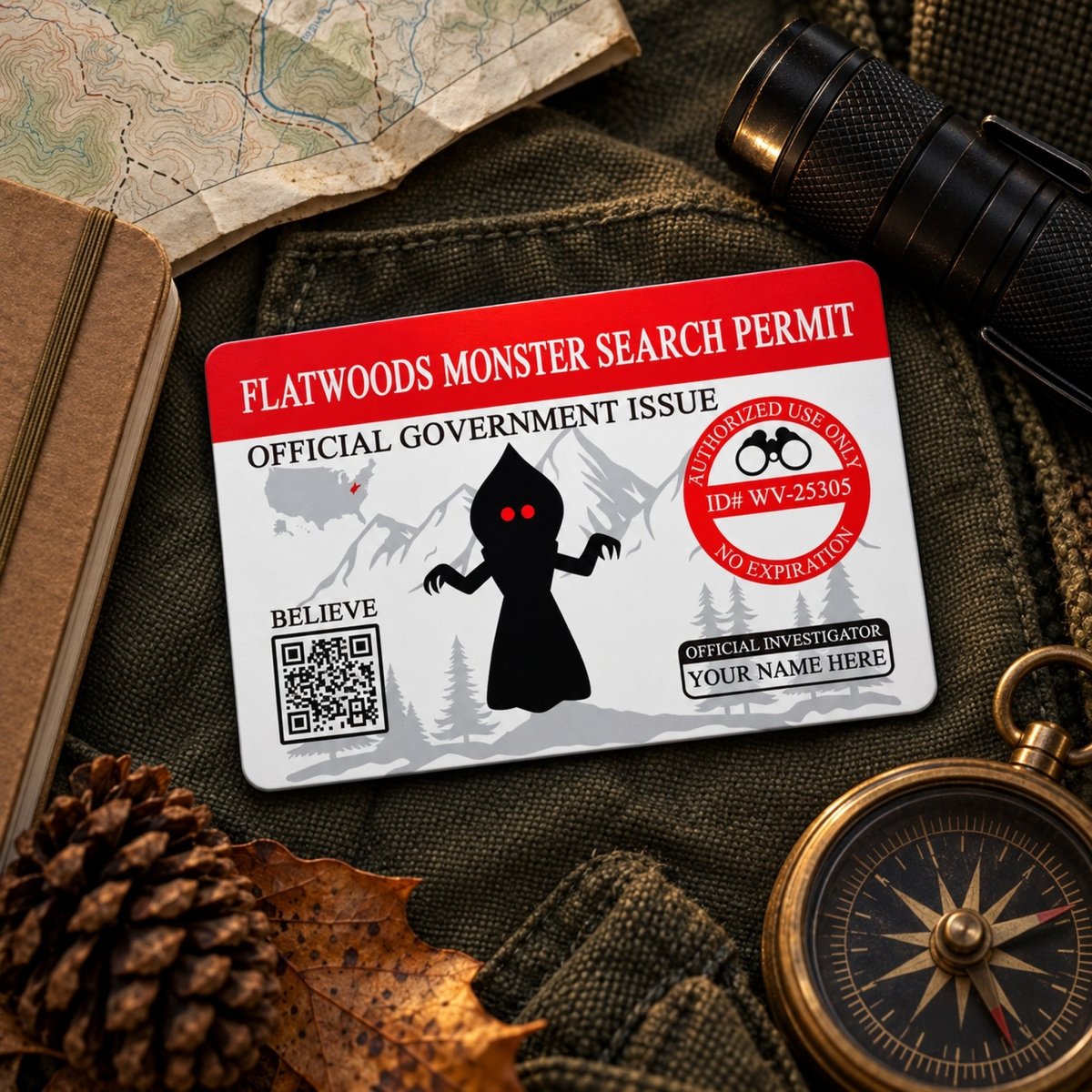 a Flatwoods Monster Search Permit card, which is an official government issued document. The card is placed on top of a map, compass, and flashlight, suggesting that it is part of an outdoor adventure or exploration scenario.