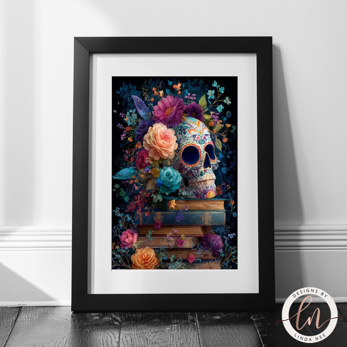 A framed artwork depicting a colorful and intricate sugar skull surrounded by a vibrant floral arrangement, with books stacked beneath it.