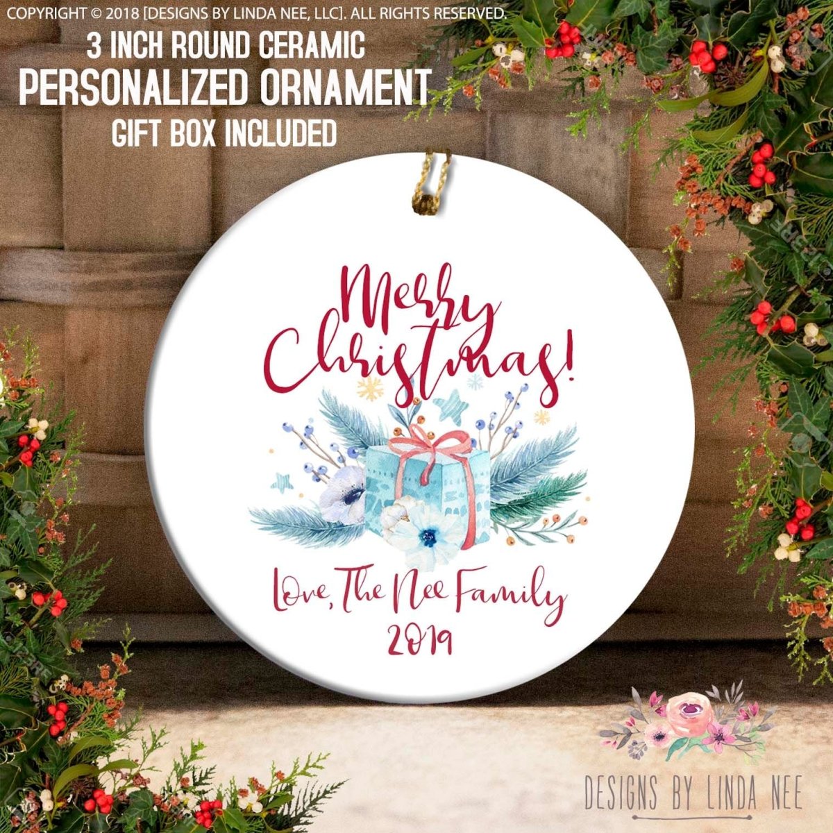 a white ceramic ornament with a festive design, including a gift box, flowers, and a ribbon. The text on the ornament reads "Merry Christmas! Love, The Nie Family 2019".