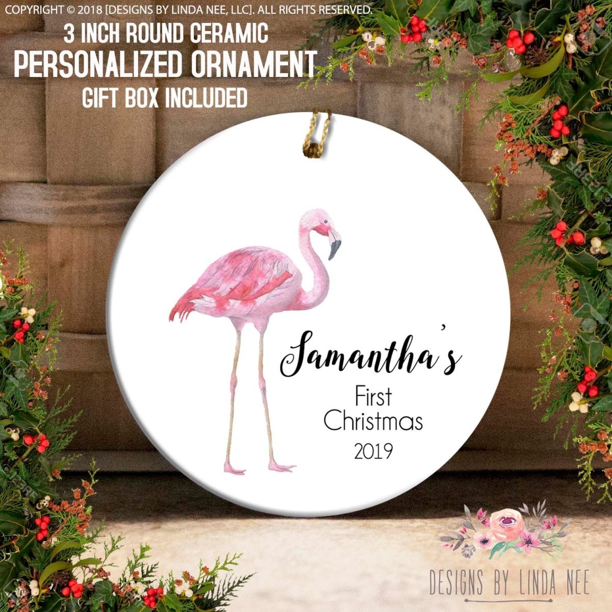 a ceramic ornament with a pink flamingo design, hanging on a wooden surface. The ornament is personalized and includes a message that reads "Samatha's First Christmas 2019".