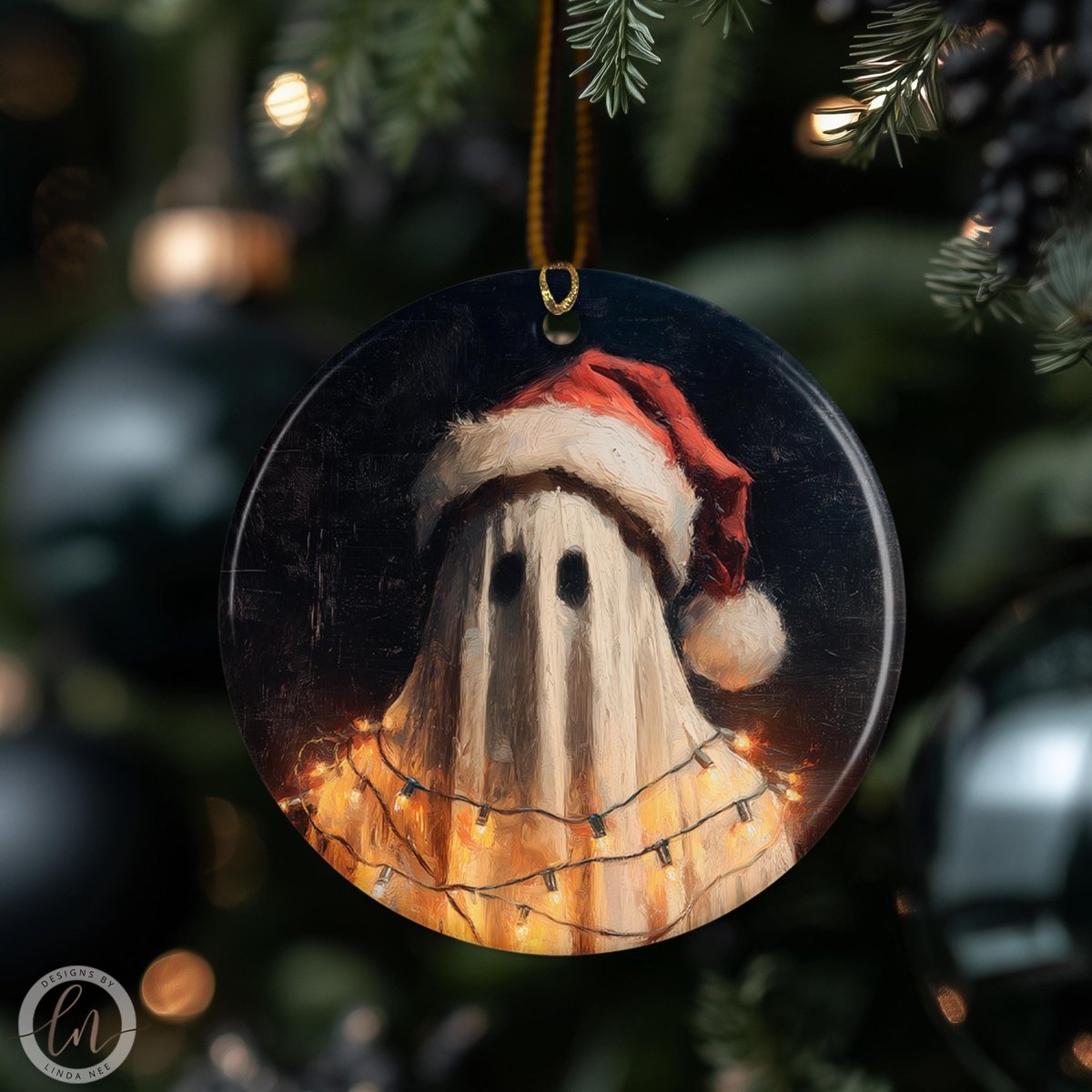 A round ornament featuring a ghost wearing a Santa hat, with a string of lights around it, hanging on a Christmas tree.