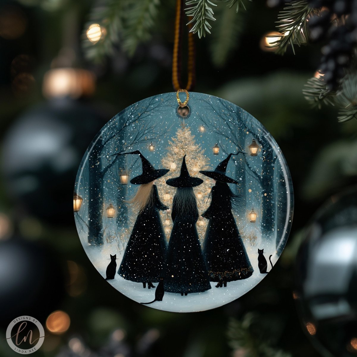 A round ornament featuring three black-haired women wearing witch hats, standing in a snowy forest with a light source in the background.
