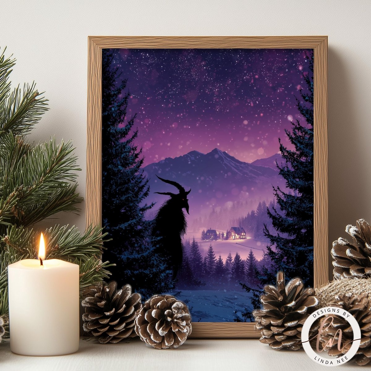 a framed picture of a snowy mountain landscape with a silhouetted animal, possibly a deer or a wolf, in the foreground. The scene is set against a starry night sky, with pine trees and a cabin visible in the background. The picture is framed in a wooden frame and is placed on a shelf or table, with a lit candle and pine cones nearby.