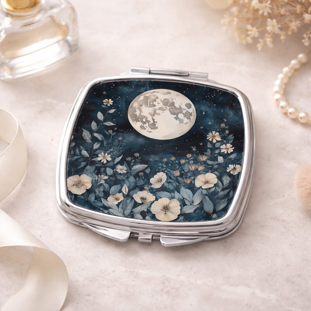 A compact mirror with a floral design and a full moon in the night sky.