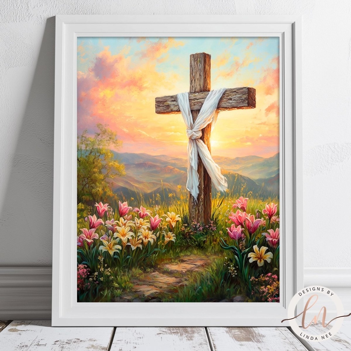 A framed painting depicting a cross surrounded by a field of flowers and a sunset landscape.