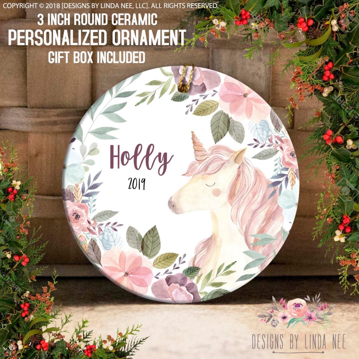 a round ceramic ornament with a floral design, including a unicorn and various flowers. The ornament is personalized with the name "Holly" and the year "2019". The ornament is surrounded by a wreath of flowers and leaves, creating a festive and decorative display.